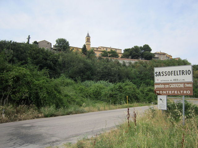 Cartello stradale e sfondo del borgo di Sassofeltrio